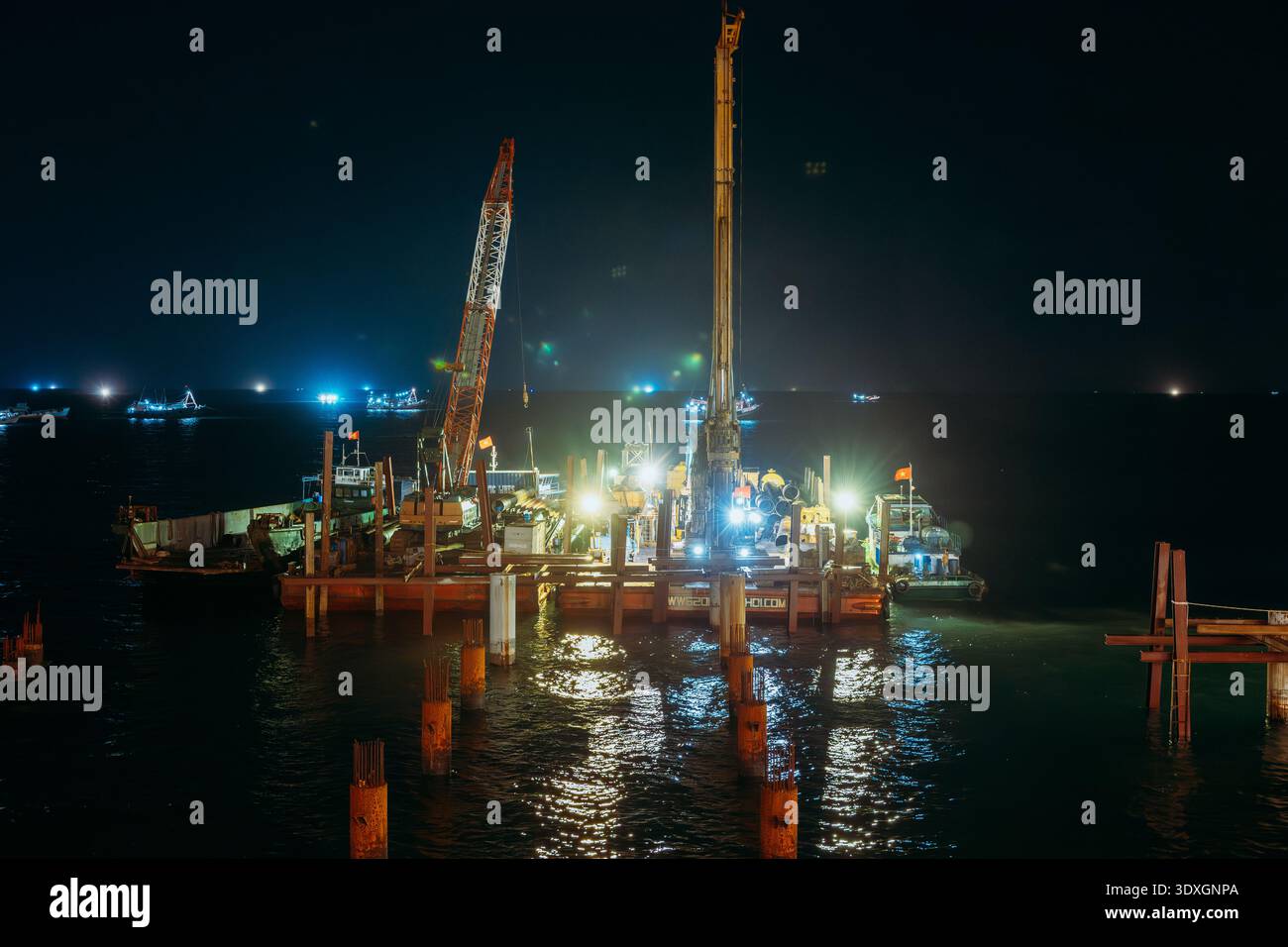 Costruzione di chiatte e gru marine che lavorano di notte nel mare di Phu Quoc Foto Stock