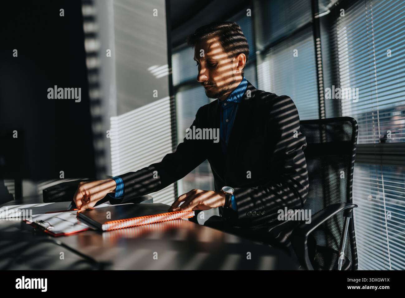 I professionisti lavorano alla scrivania in un ufficio moderno con ombre luminose a righe Foto Stock