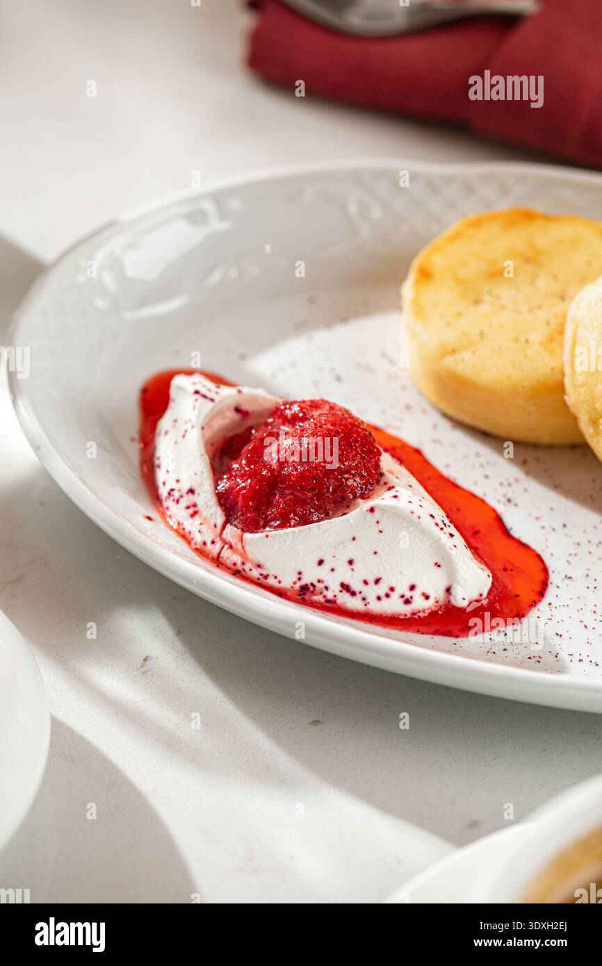 Syrniki con panna acida e marmellata di bacche Foto Stock