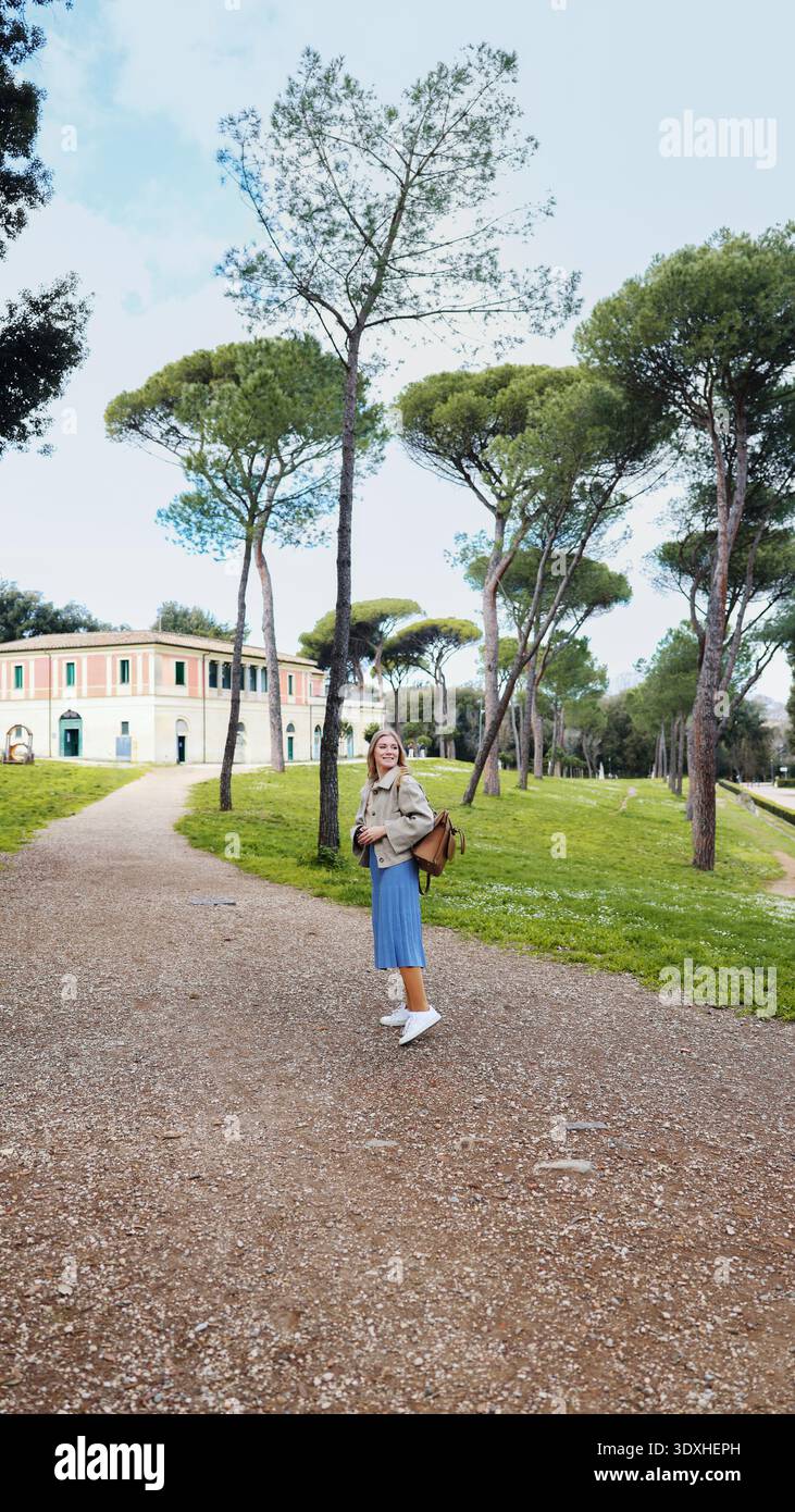 Donna elegante che esplora il parco verde di Roma. Turismo e atmosfera urbana. Foto Stock