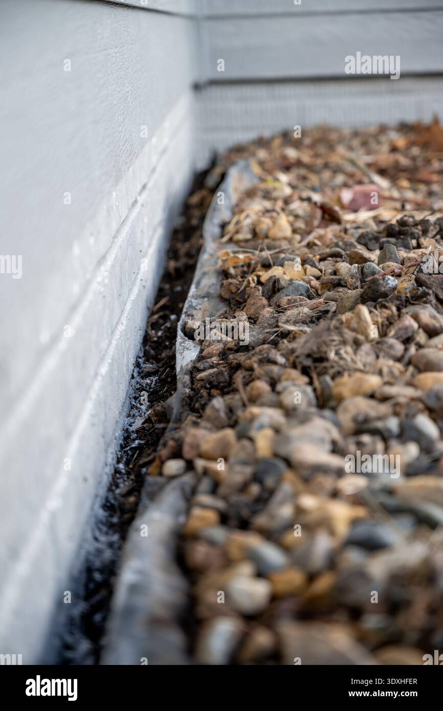 Allontanare la barriera di roccia e erbacce da una parete per la verniciatura. Foto Stock