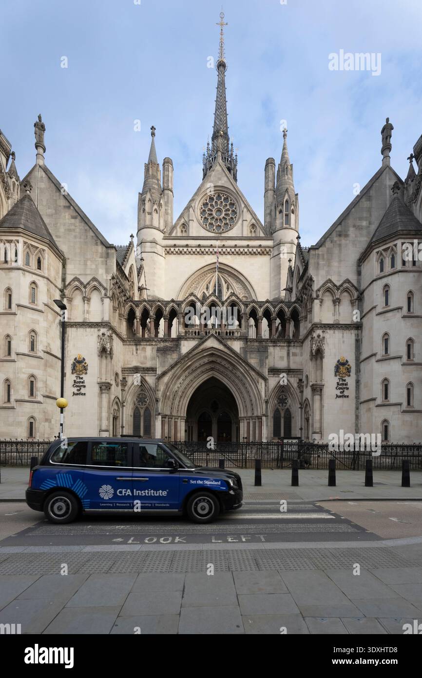 Un taxi del CFA Institute passa davanti alla Royal Courts of Justice di Londra Foto Stock