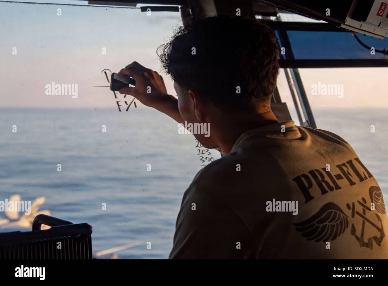 La USS Abraham Lincoln (CVN 72) è una portaerei classe Nimitz della Marina degli Stati Uniti. Questa fotografia d'archivio cattura un marinaio statunitense che segue le operazioni di volo dal controllo di volo principale a bordo della portaerei mentre sostiene l'operazione Epic Fury il 28 febbraio 2026. Foto Stock