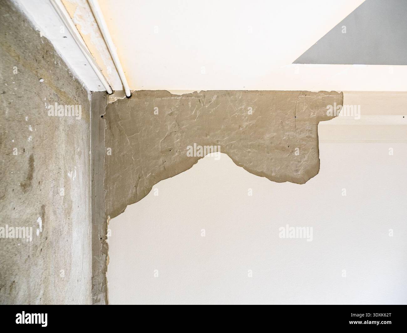 vista dal basso del soffitto con intonaco scheggiato in camera durante la ristrutturazione dell'appartamento Foto Stock