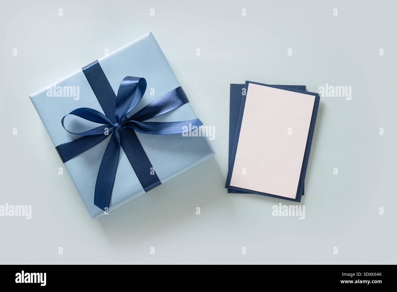 Confezione blu con biglietto d'auguri vuoto su sfondo pastello. Concetto del giorno del padre. Layout minimo. Foto Stock