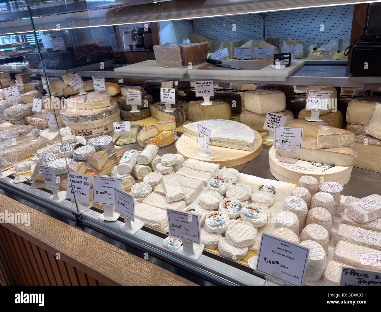 Selezione di formaggi artigianali / Fromage. Ampia varietà di formaggi francesi, tra cui formaggio di capra a latte crudo (Chèvre) e formaggi a pasta molle, esposti in un frigorifero Foto Stock