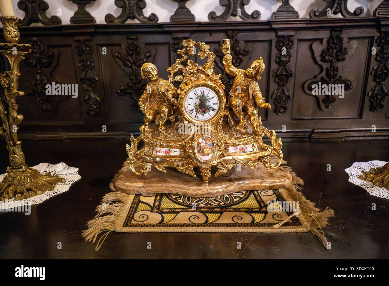 Grenada, Spagna - 19 dicembre 23: Primo piano di un orologio decorato dorato con statuette e numeri romani all'interno della Basilica de San Juan de Dios di Gra Foto Stock