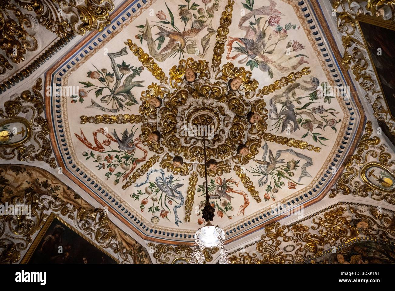 Vista ravvicinata del soffitto ottagonale dipinto con motivi floreali e ornamenti dorati nella Basilica de San Juan de Dios, Granada, Andalusia, Spagna. Foto Stock