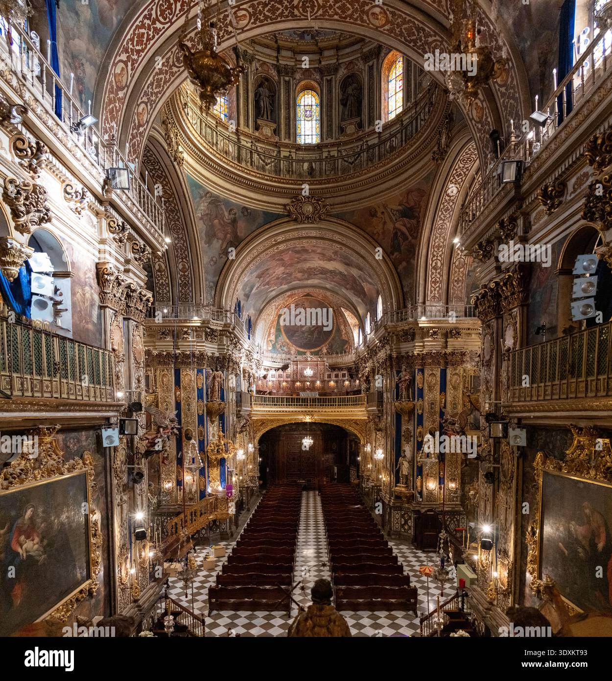Grenada, Spagna - 19 dicembre 23: Vista panoramica dalla navata riccamente dorata con cupola, balconi, affreschi e lampadari all'interno della Basilica de San Juan de D. Foto Stock