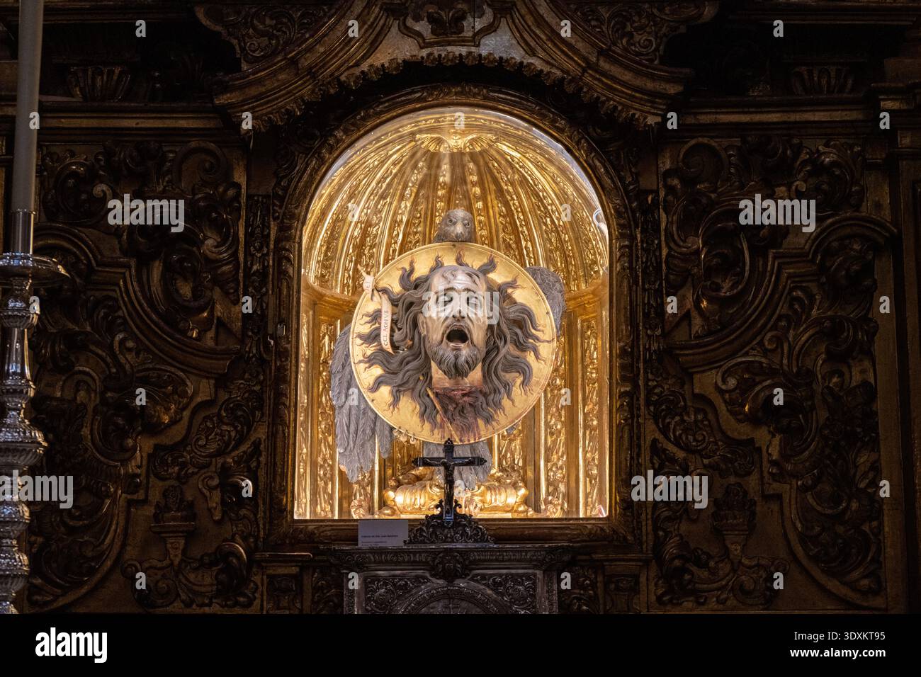 Grenada, Spagna - 19 dicembre 23: Nicchia devozionale illuminata con decorazioni barocche dorate e un'icona sacra all'interno della Basilica di San Juan de Dios, Granada Foto Stock