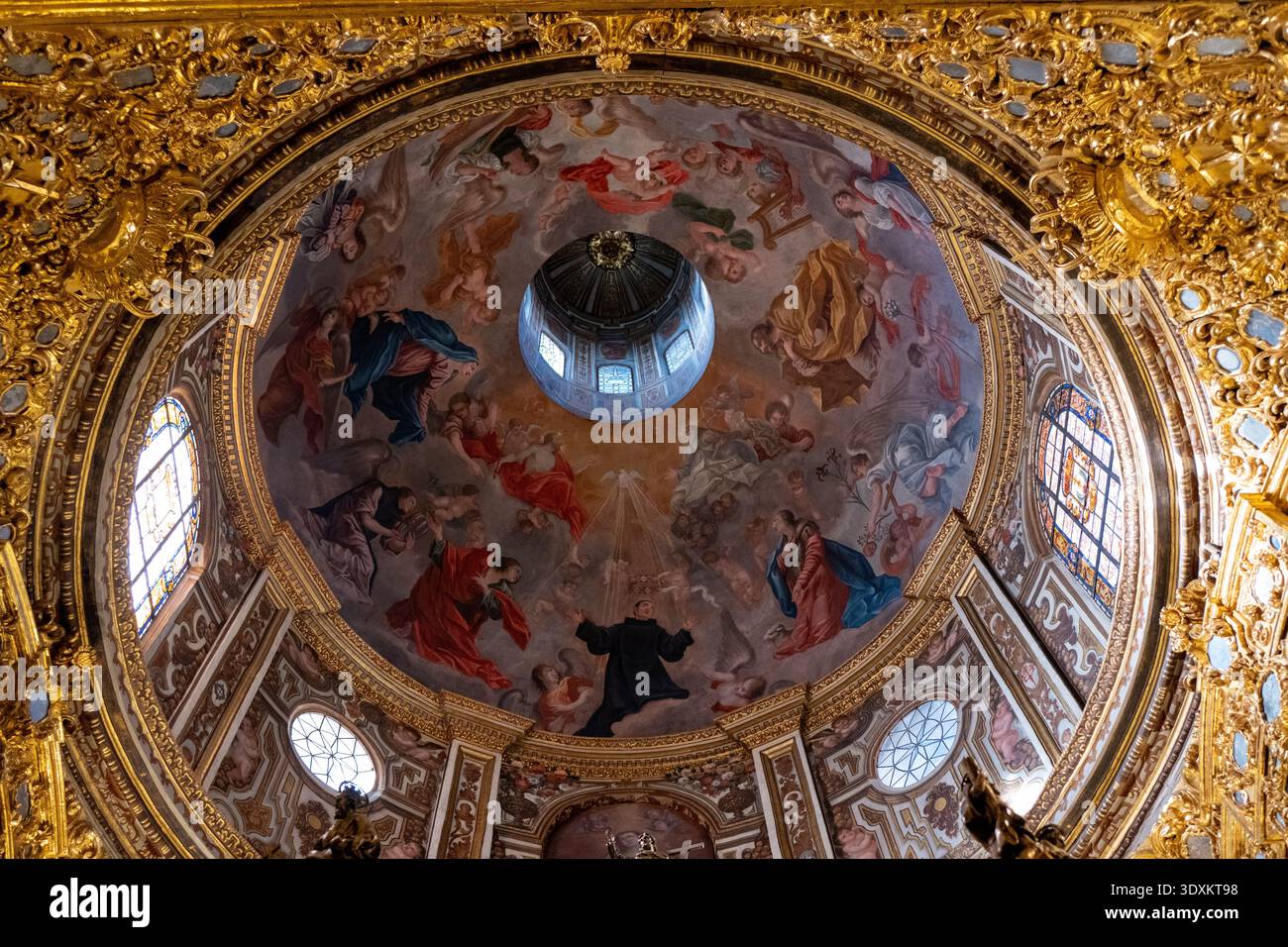 Grenada, Spagna - 19 dicembre 23: Vista verso l'alto della cupola dipinta con oculo, cornice dorata e affreschi nella Basilica de San Juan de Dios, Granada, Andalusia Foto Stock