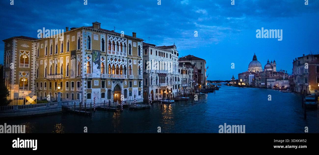 Ora blu sul Canal Grande con il palazzo Cavalli-Franchetti illuminato a sinistra e Santa Maria della Salute sullo sfondo, Venezia, Italia Foto Stock