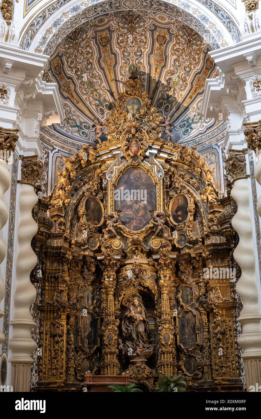 Siviglia, Spagna - 23 dicembre 23: Vista verticale di un retablo riccamente dorato incorniciato da colonne ritorte e volta dipinta all'interno di San Luis de los Franceses, Sev Foto Stock