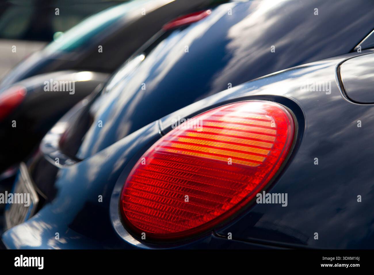 Un paio di Volkswagen (VW) Beetles parcheggiati uno accanto all'altro in un parcheggio Foto Stock