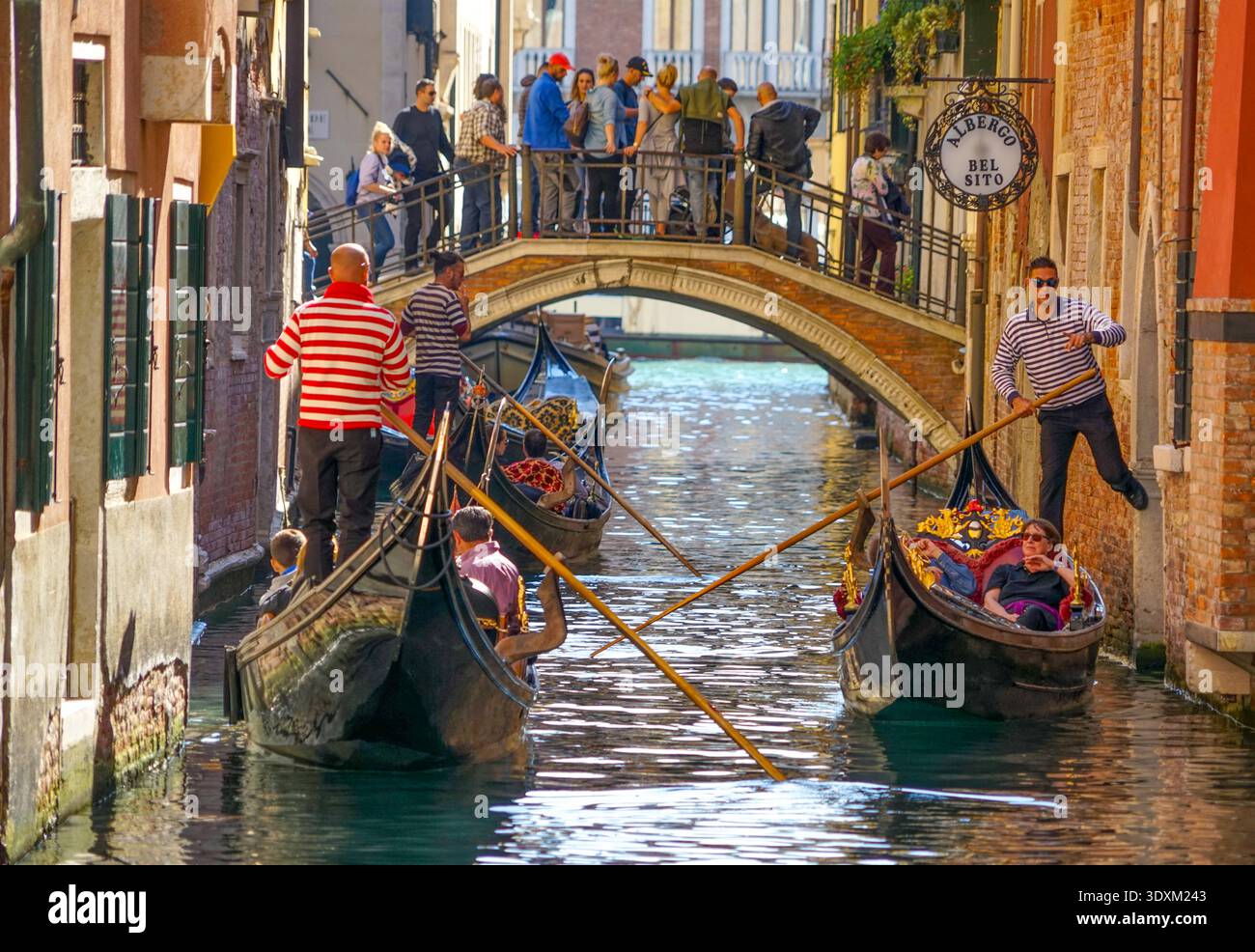 I gondolieri remano turisti davanti alle facciate di mattoni sul canale Rio de l'Albero, San Marco, Venezia, Italia Foto Stock