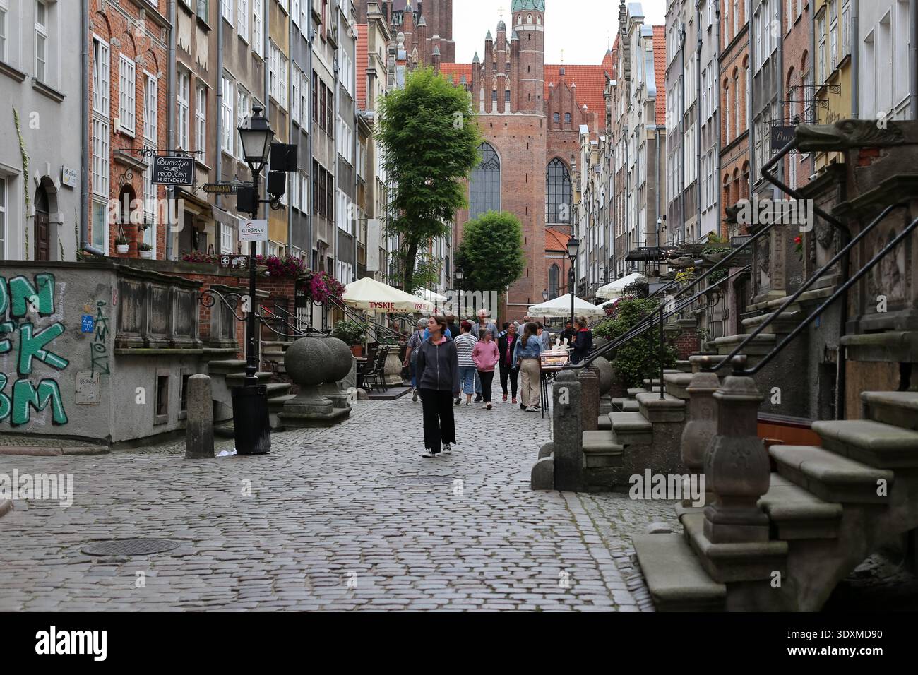Via Mariacka nella città vecchia di Danzica con case storiche, strade acciottolate e pedoni vicino alla chiesa di Santa Maria, Polonia. Foto Stock