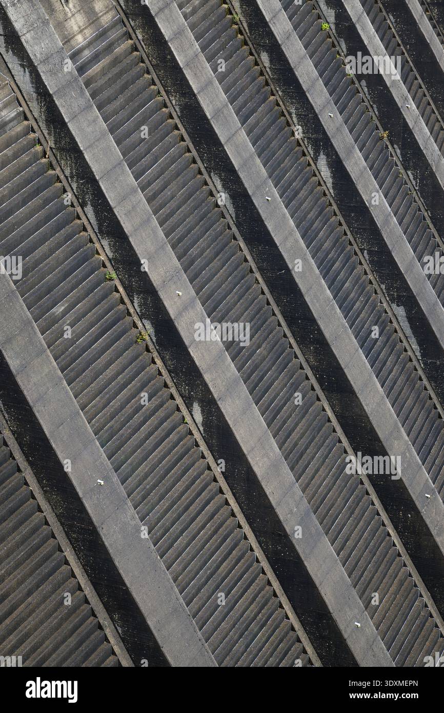 Superficie robusta del muro della diga in primo piano con canale di trabocco in struttura artificiale Foto Stock