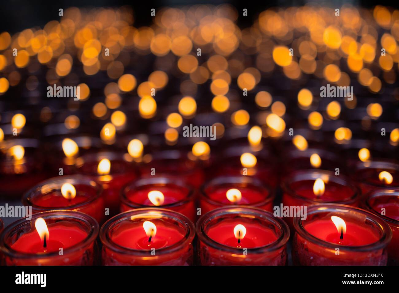 Le candele rosse emettono una luce calda, creando un'atmosfera di spiritualità e calma Foto Stock