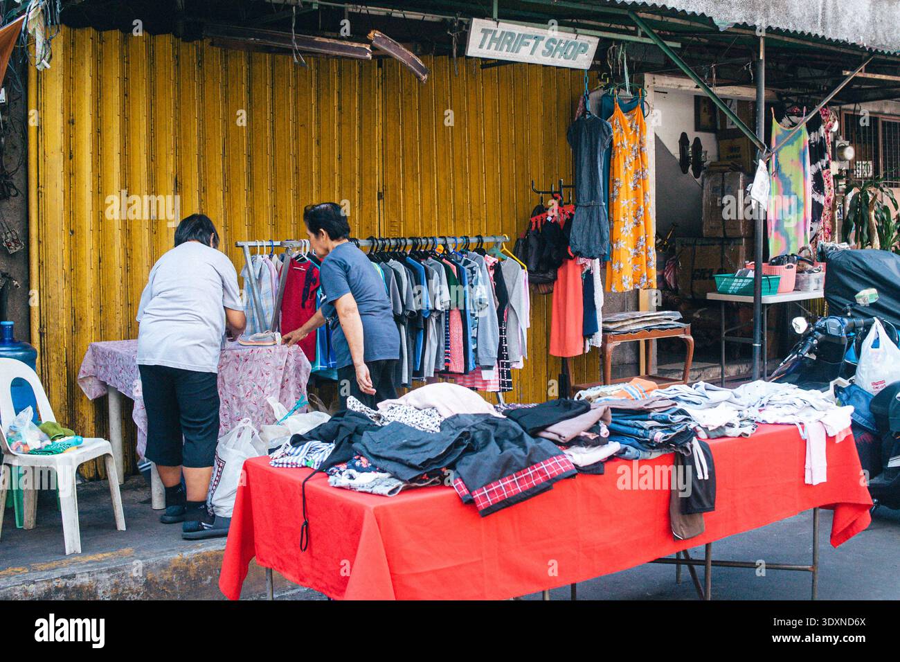 Cliente che cerca abiti di seconda mano nel Thrift Store Foto Stock