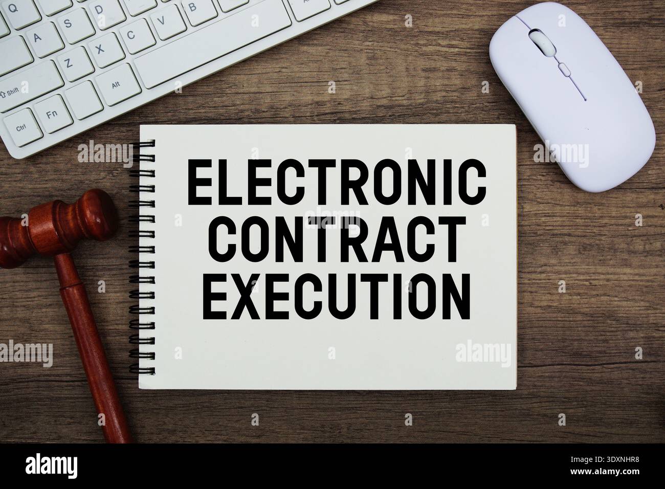 Testo di esecuzione elettronica del contratto scritto con martelletto, tastiera e mouse ottico su sfondo in legno Foto Stock