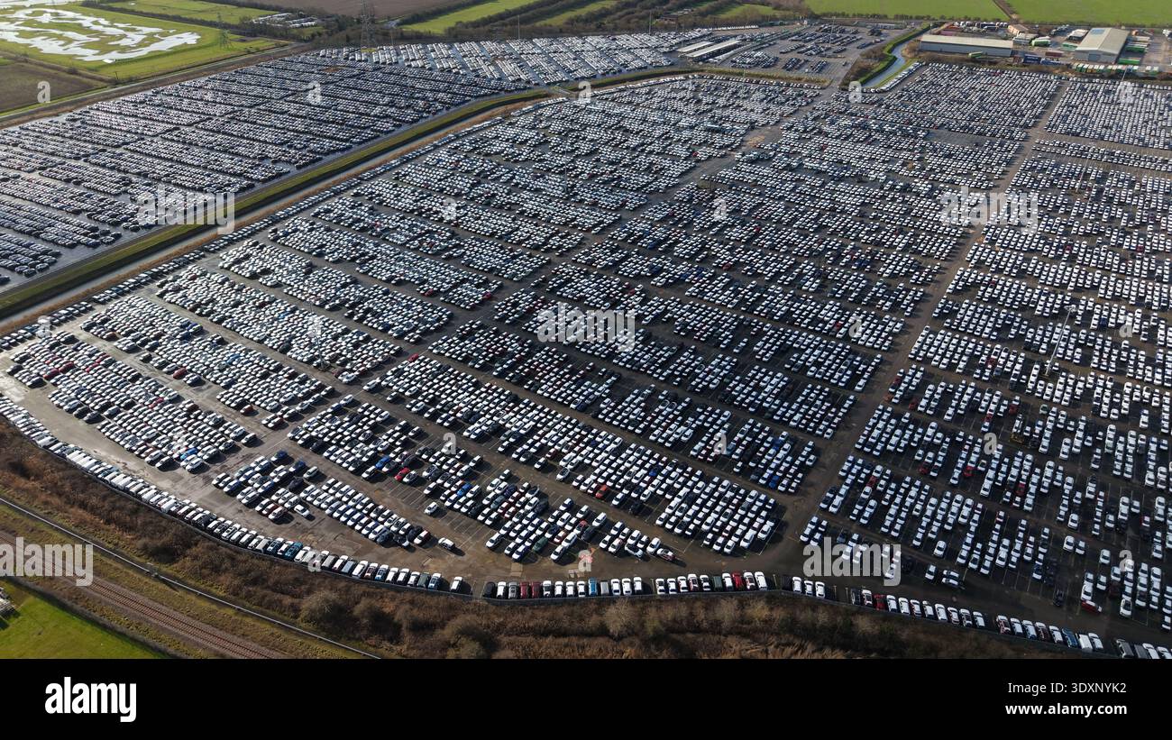 La vista aerea di file su file di auto riempie il paesaggio, estendendosi come un oceano metallico sotto un cielo tenue, Grimsby, Regno Unito. Foto Stock