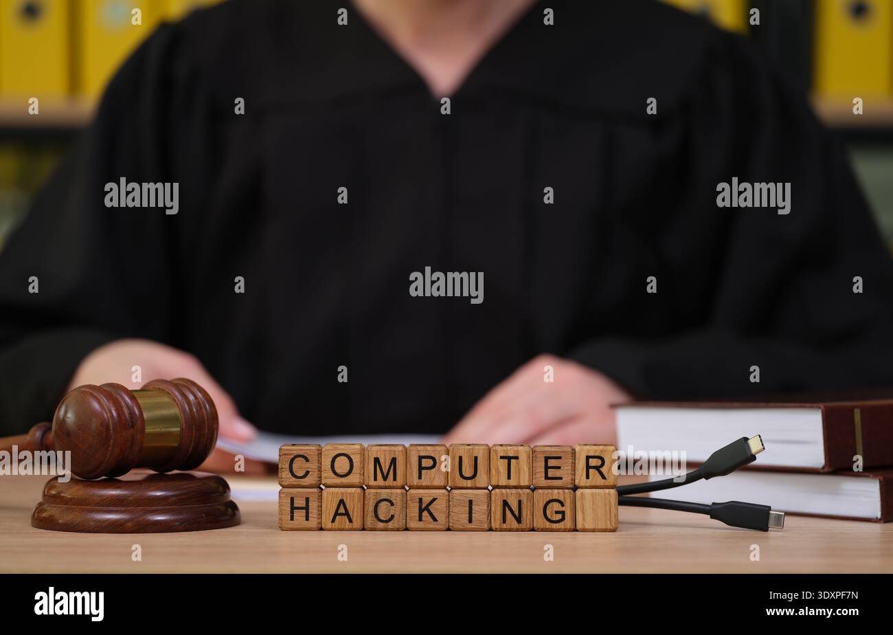 La scena del tribunale mostra il giudice che affronta il caso di hacking informatico in mezzo a documenti legali e martelletto di legno Foto Stock