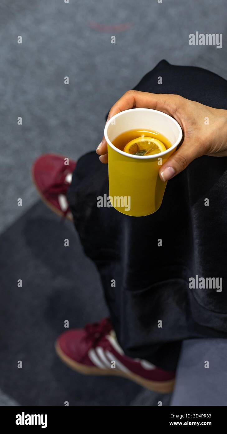 Tazza di carta gialla con tè al limone caldo Foto Stock