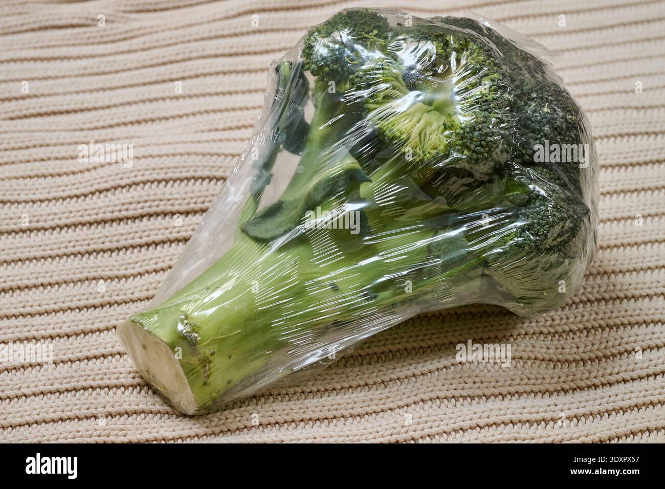 Broccoli avvolti in una pellicola di plastica su fondo di lana Foto Stock