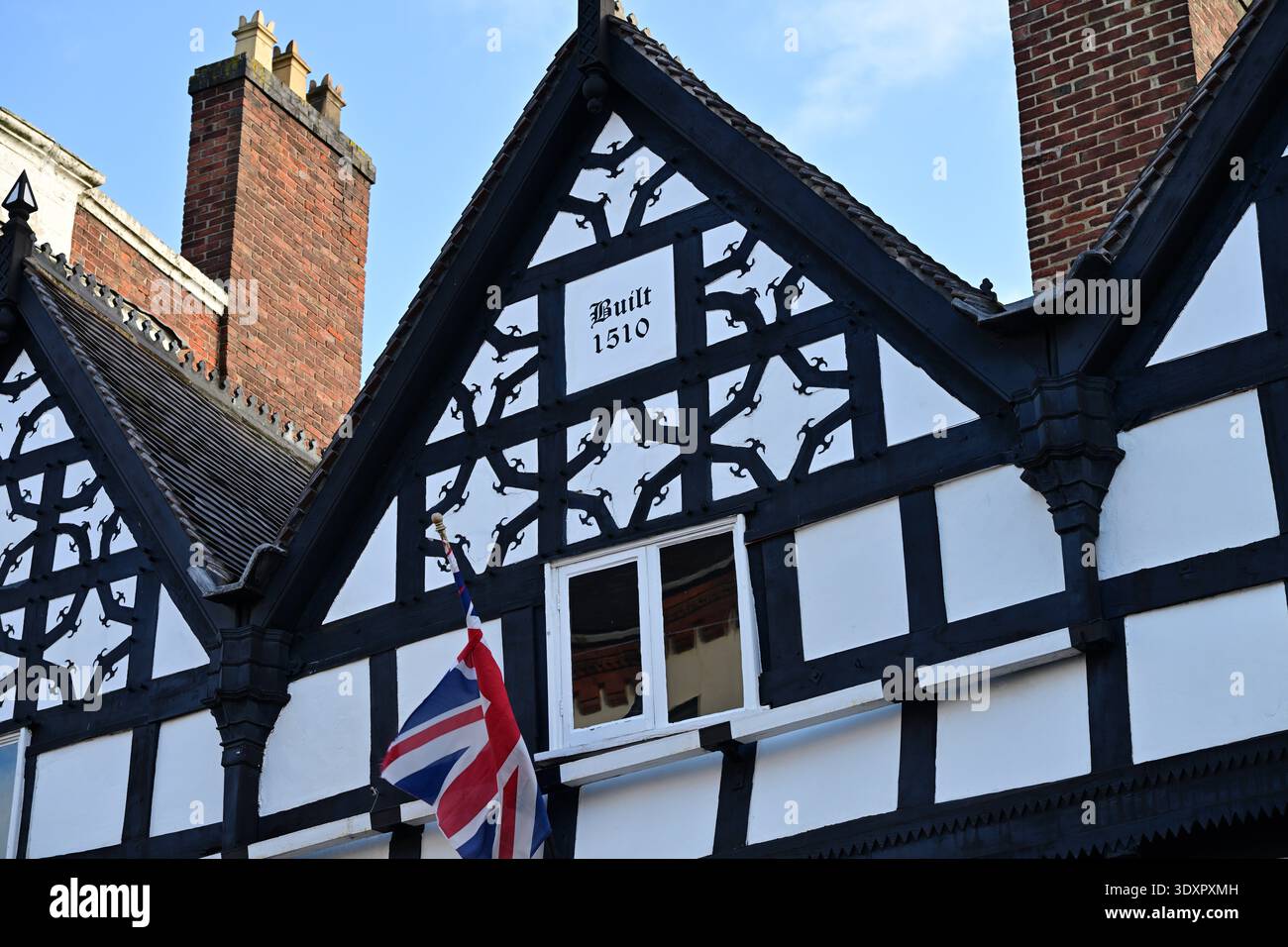 Edificio in legno Tudor con Union Jack e data storica Foto Stock