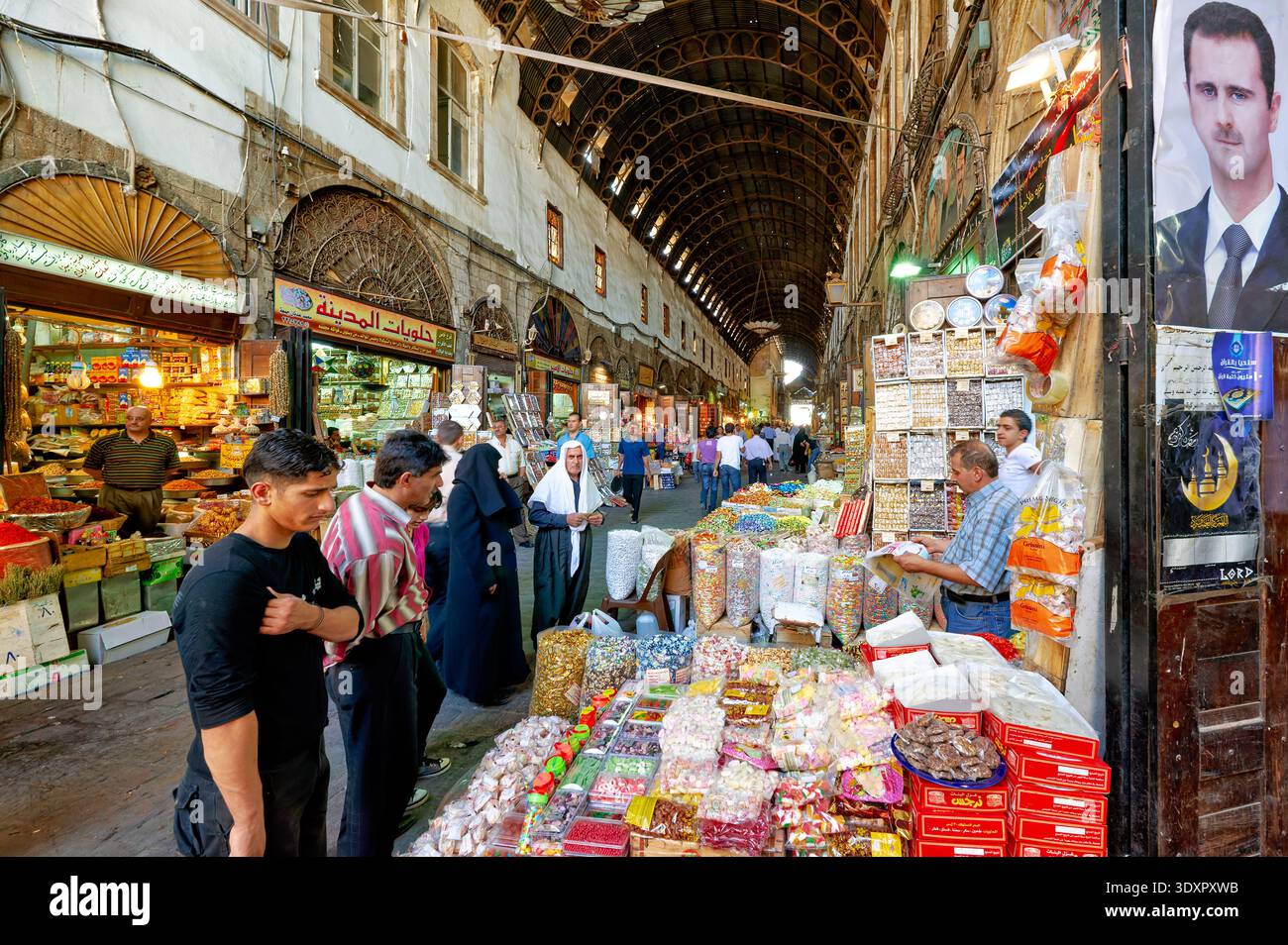 La gente fa shopping e cammina attraverso il suq di al-Hamidiyah a Damasco. Le bancarelle espongono varie merci. L'attività è intensa durante il giorno. Foto Stock