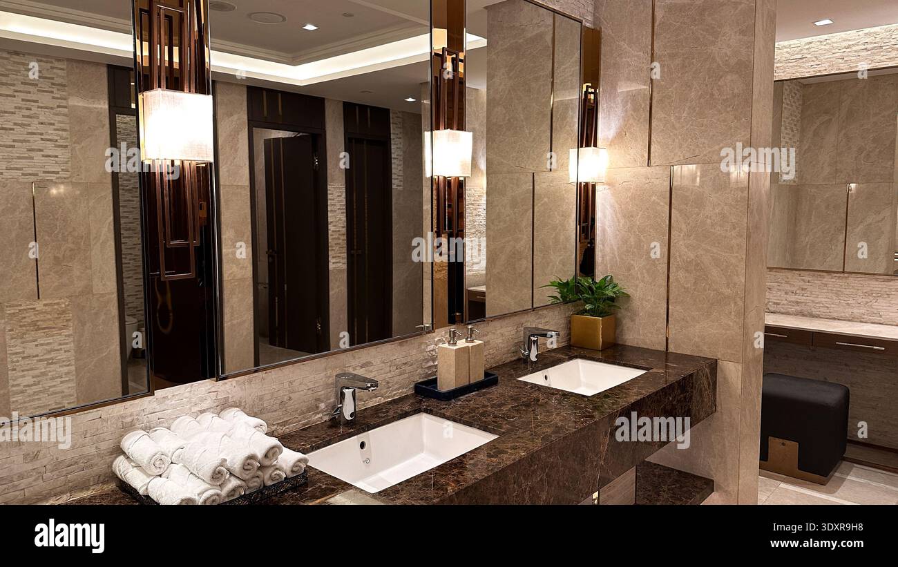 Eleganti interni del bagno con doppio lavabo con ripiano in marmo ed eleganti impianti di illuminazione Foto Stock