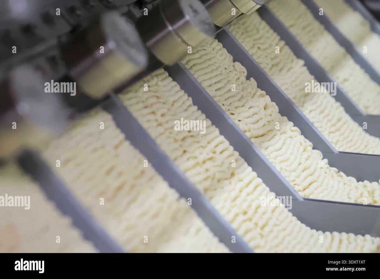 Linea di produzione istantanea di spaghetti. porzioni di spaghetti sul trasportatore, industria alimentare di massa. Foto Stock