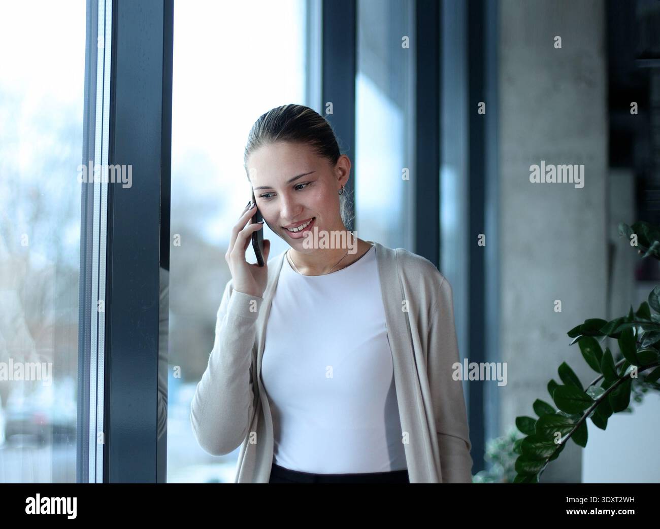 Una donna sta parlando al cellulare mentre sorride Foto Stock