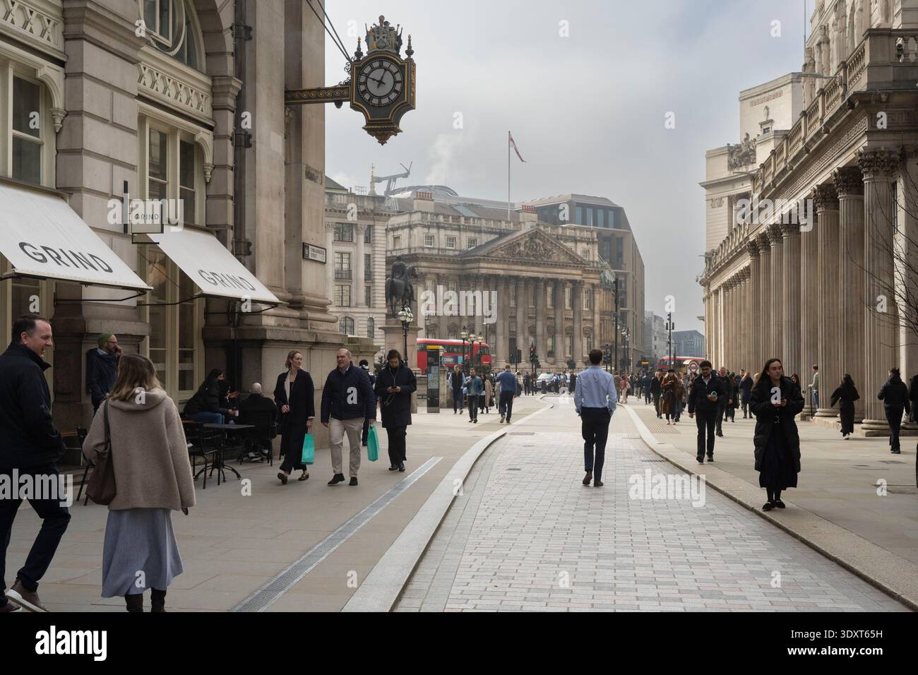 La gente passa davanti al Royal Exchange in Threadneedle Street, Londra, vicino all'iconico orologio. Foto Stock