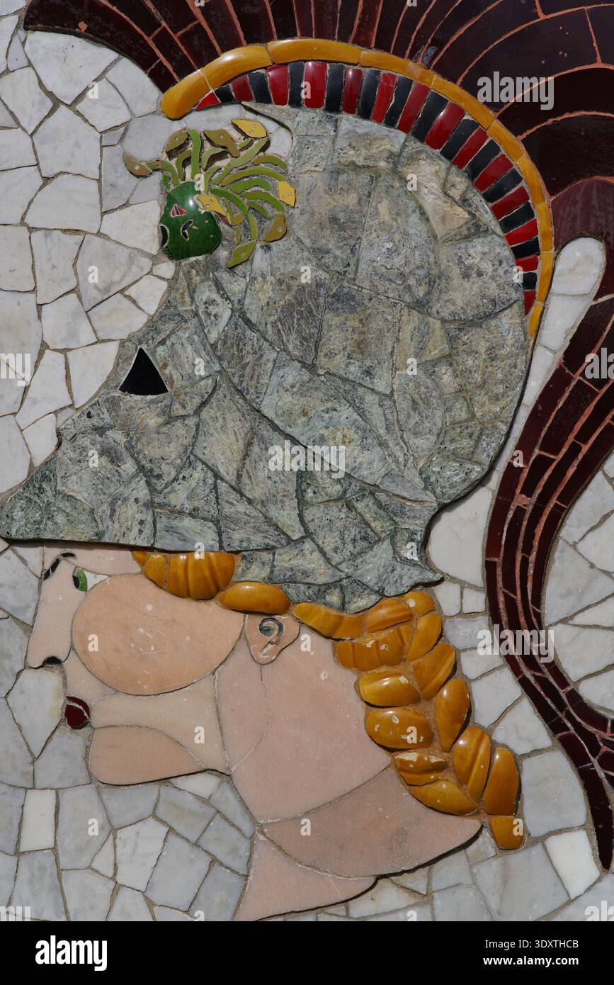 Intricato mosaico di un classico profilo guerriero con elmetto decorato, capelli arancioni intrecciati e stemma verde sul pavimento in pietra della città vecchia di Nizza. Foto Stock