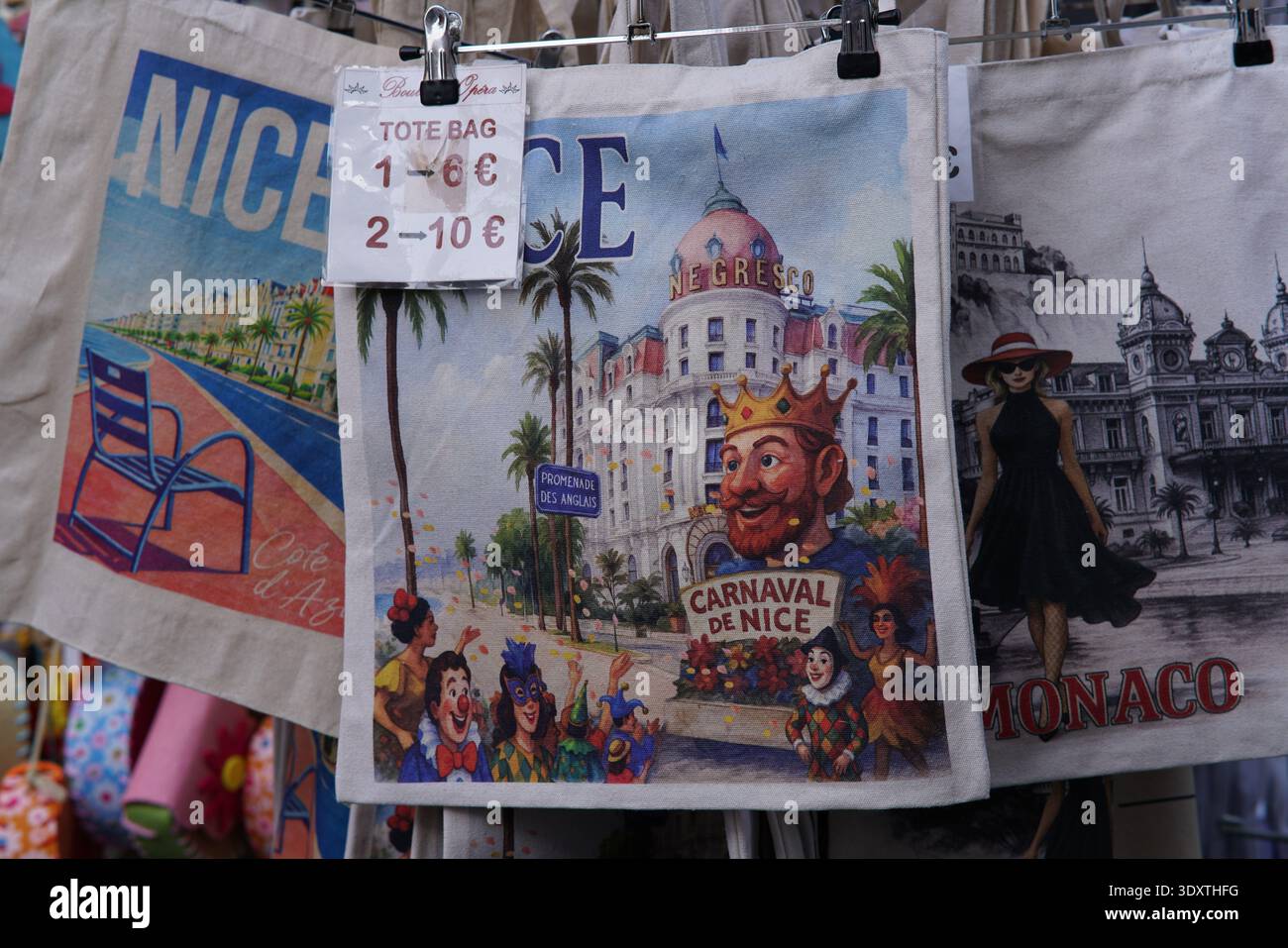Borse tote colorate di Nizza in mostra con sfilata del Carnaval de Nice con la figura del re incoronato, l'Hotel Negresco e scene sulla spiaggia per 2-10 €. Nizza, Francia Foto Stock