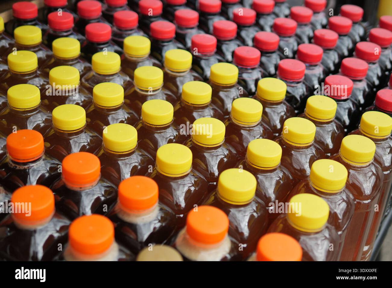 Bottiglie allineate con tappi colorati per la vendita in un mercato Foto Stock