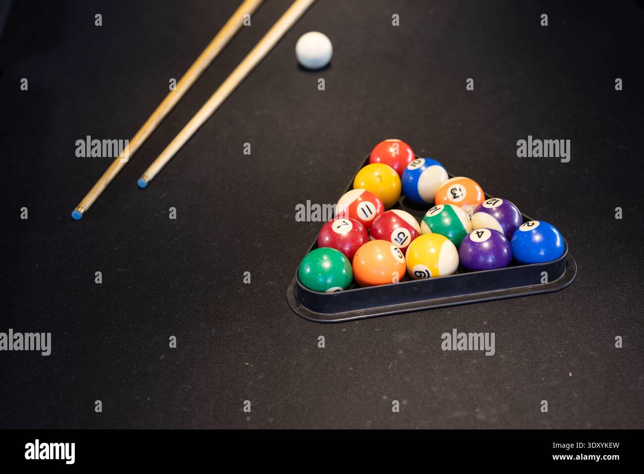 Rack triangolare con 15 palline numerate lucide su feltro scuro, segnali distesi diagonalmente, spazio di copia Foto Stock