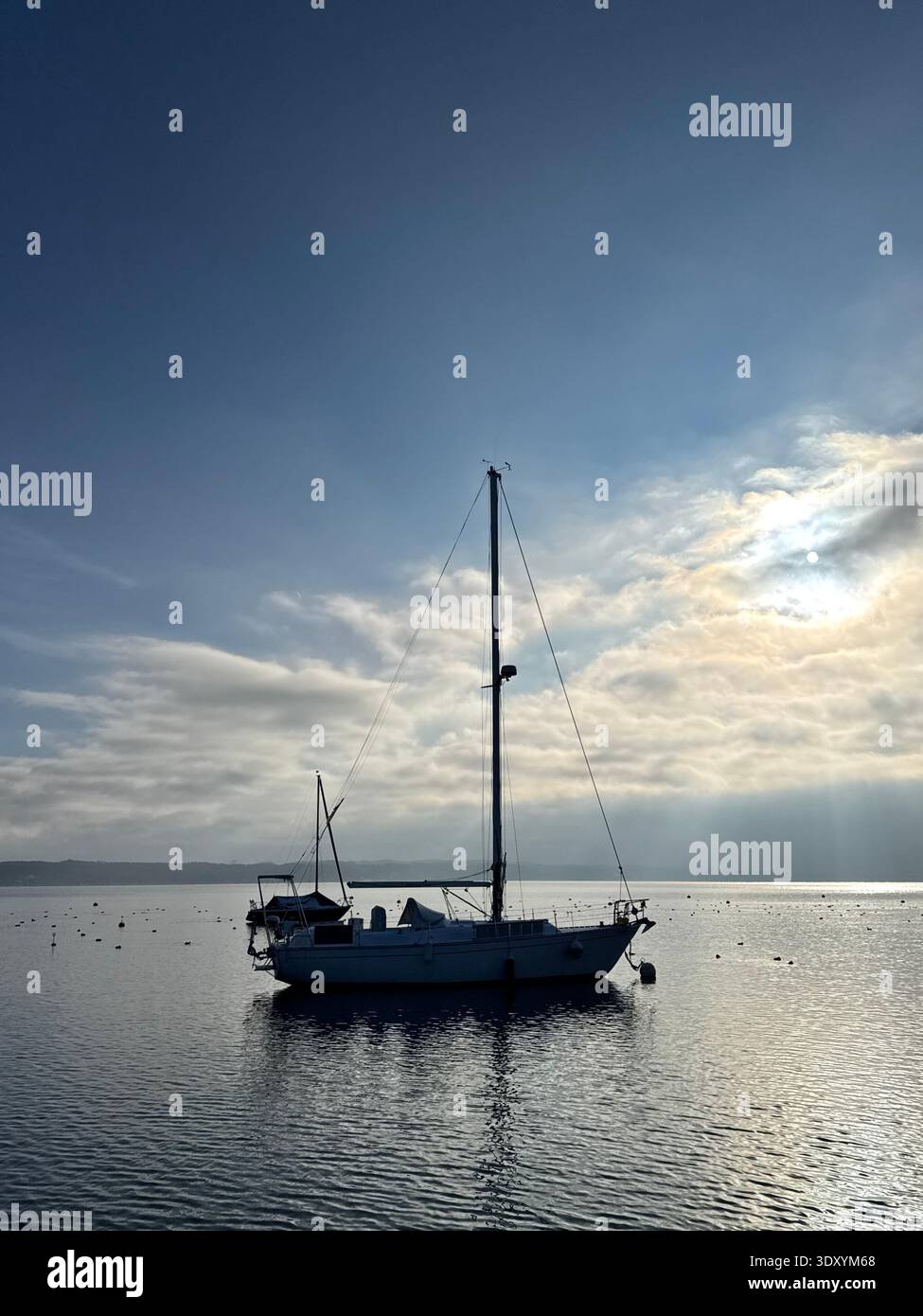 barca a vela sotto il sole che si infrangono sulle nuvole di tempeste - Immagine stock catturata con smartphone