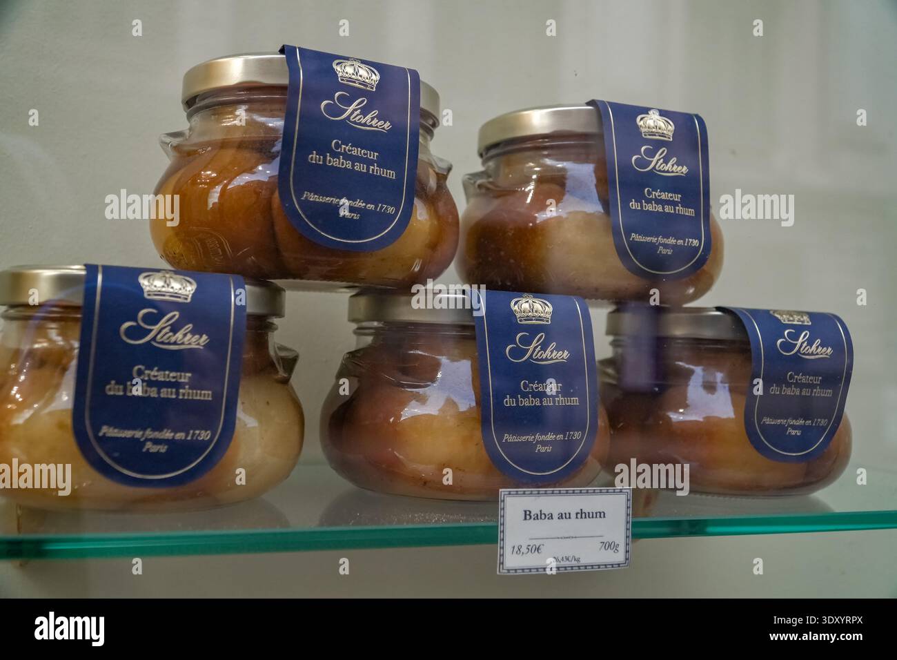 Stohrer Baba au rhum jars. Bene, Francia. Mostra di dolci al rum baba della pasticceria più antica di Parigi, fondata nel 1730, dietro vetro. Foto Stock