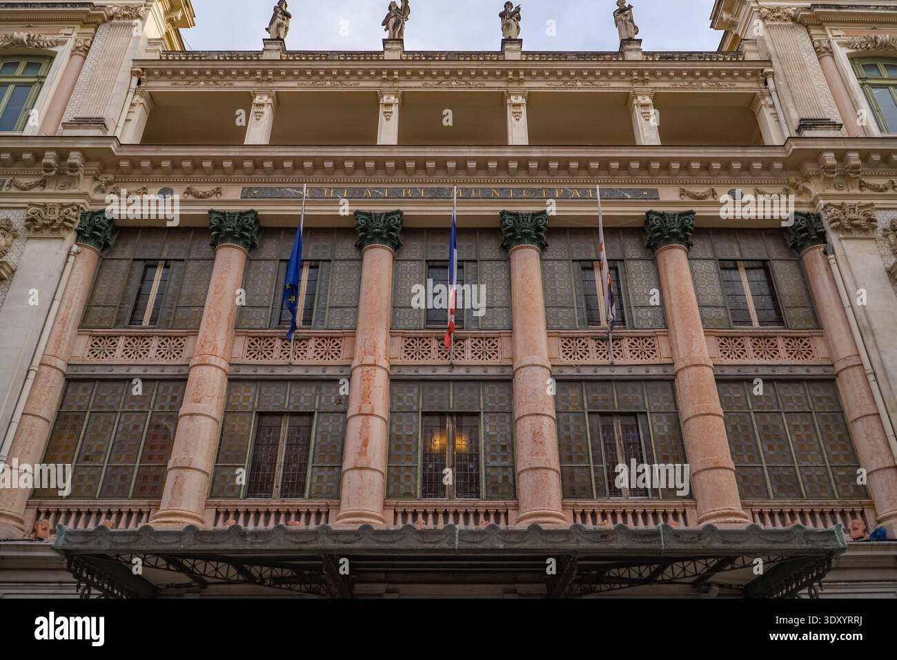 Opéra de Nice, municipale di Théâtre. Bene, Francia. Dettagli architettonici del secondo Impero con capitelli ornati e bandiere UE/francesi che volano. Foto Stock