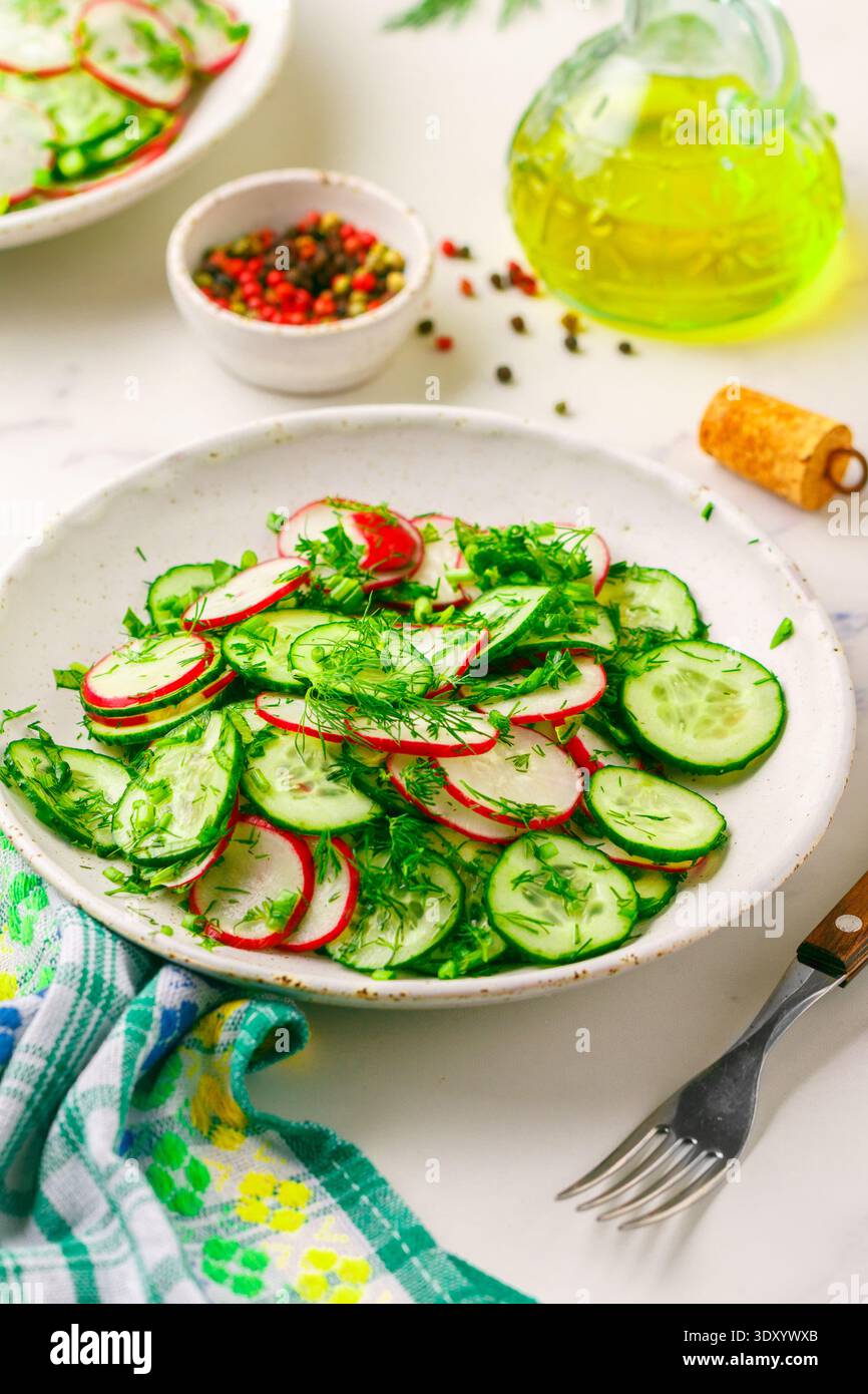 Insalata vegetariana di verdure fresche, ravanelli, cetrioli, aneto, prezzemolo e cipolle verdi con olio d'oliva e spezie. Antipasto vitaminico. Dieta, disintossicazione. Lui Foto Stock