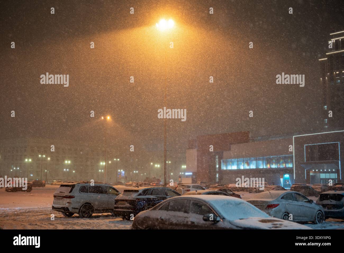 Abbondanti nevicate invernali e bufera di neve in città, parcheggio con auto vicino al supermercato coperto di neve. Foto Stock