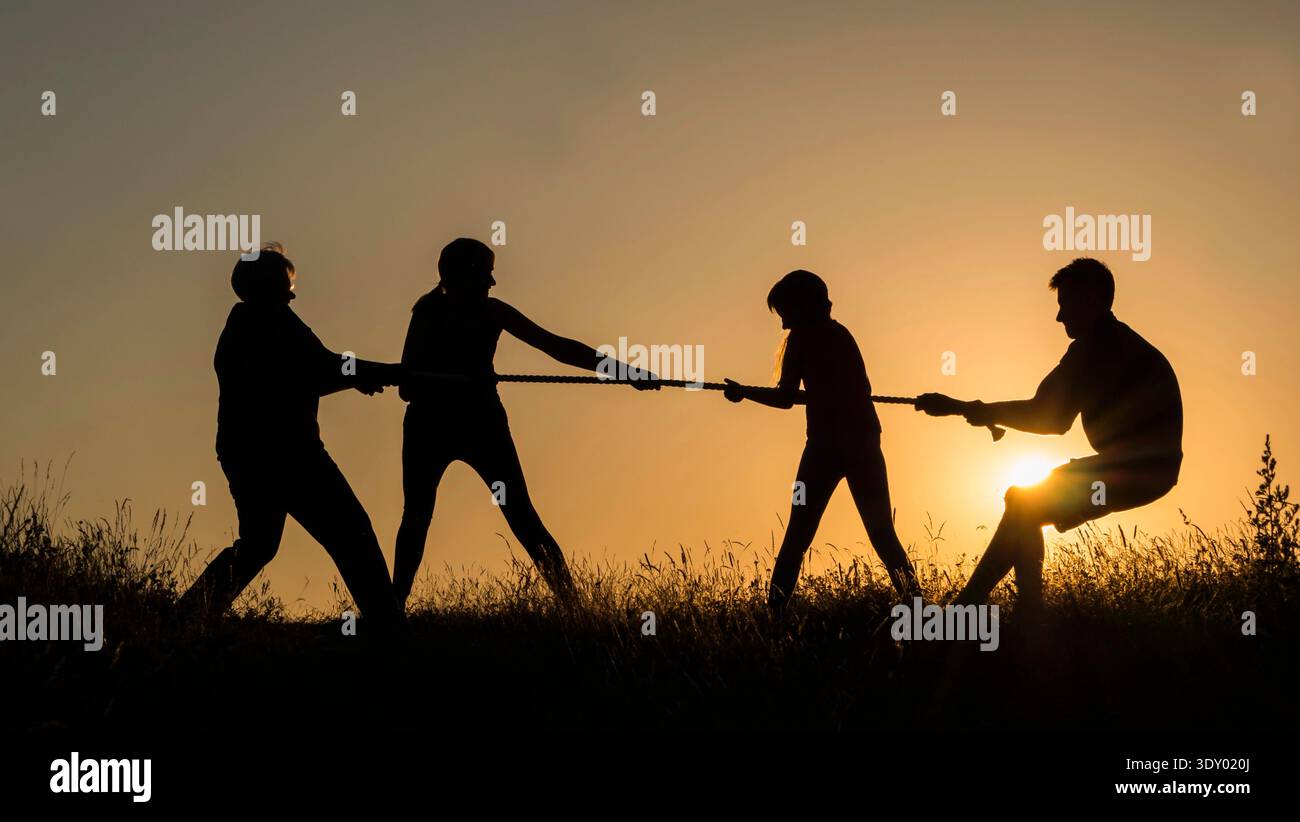 Famiglia che si diverte in natura, giocando a tiro di guerra Foto Stock