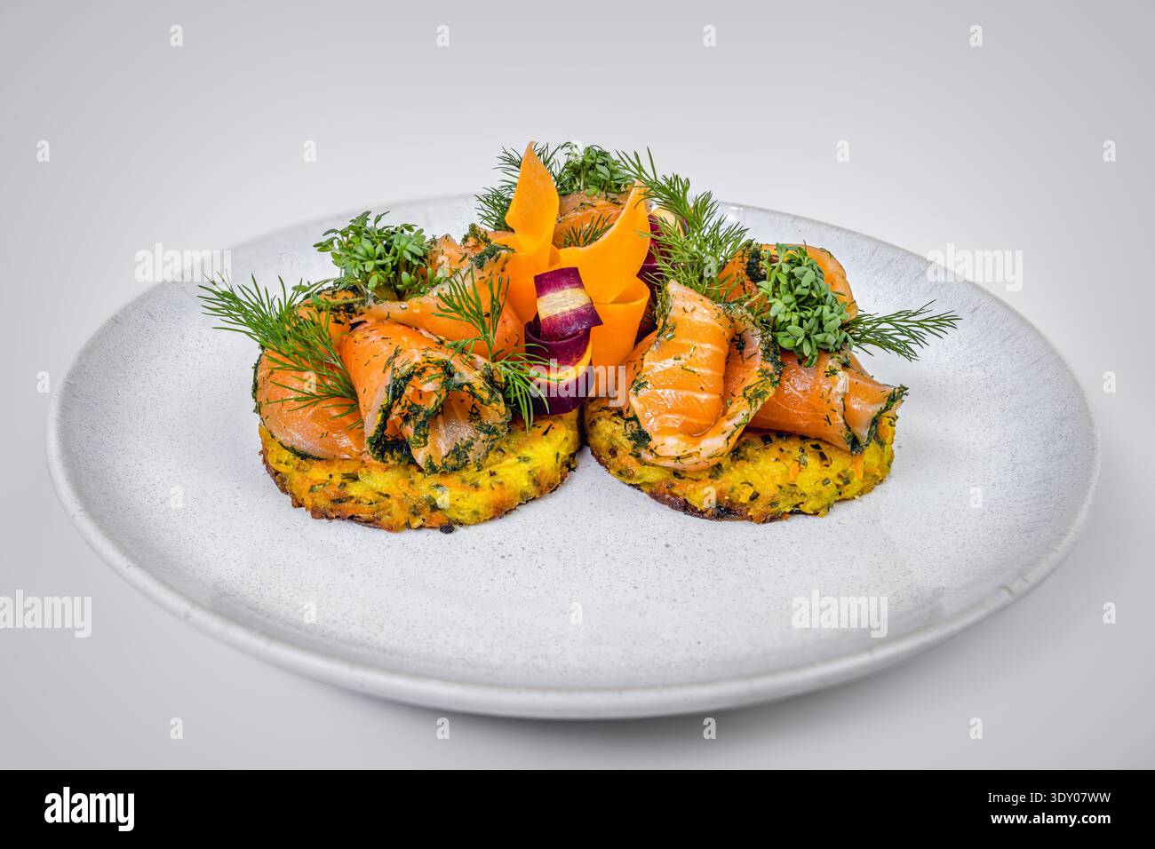 Eleganti rosette di salmone affumicato su Rösti di patate croccanti con salsa alle erbe Foto Stock