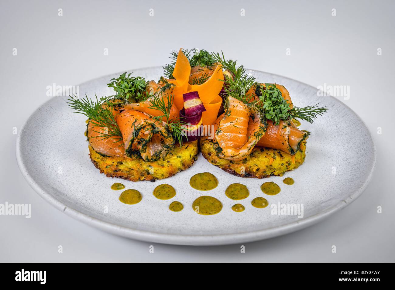 Eleganti rosette di salmone affumicato su Rösti di patate croccanti con salsa alle erbe Foto Stock