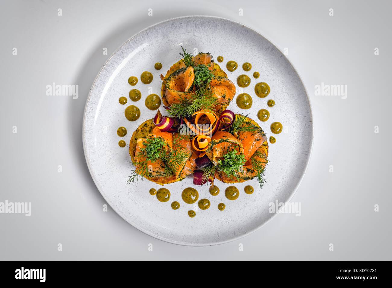 Eleganti rosette di salmone affumicato su Rösti di patate croccanti con salsa alle erbe Foto Stock