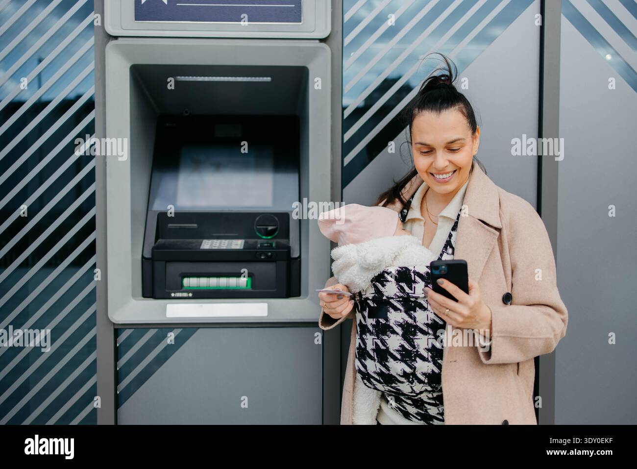 Usando un bancomat in una città Foto Stock