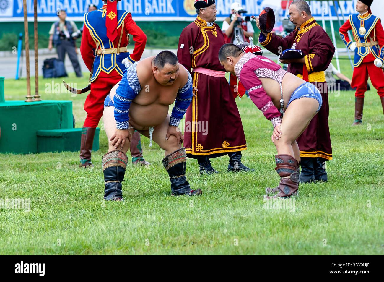 Due lottatori gareggiano durante il festival Naadam a Ulan Bator. La folla guarda le partite tradizionali che si svolgono in un'atmosfera vivace. Foto Stock