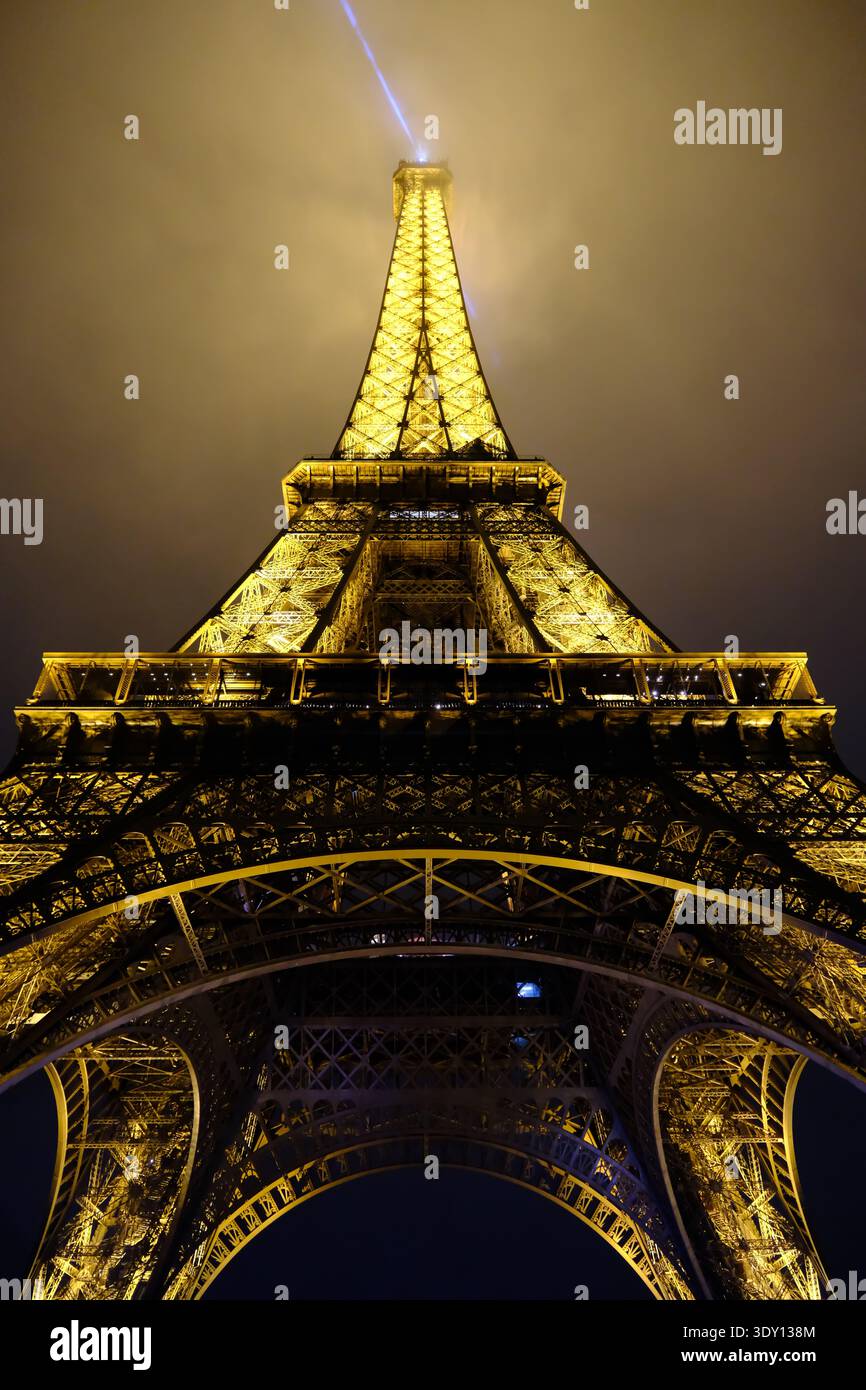 Parigi, Francia - 3 ottobre 2025: Ripresa verticale ad angolo basso della Torre Eiffel con illuminazione simmetrica di notte Foto Stock